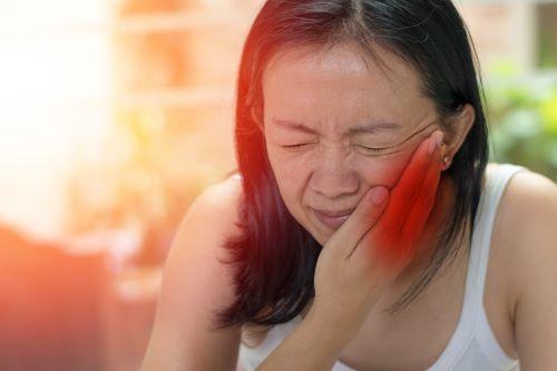 woman holding jaw from pain during dental emergency