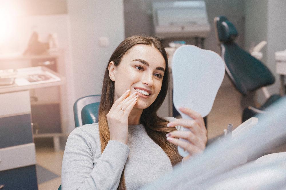 woman checking out her smile in a dental mirror