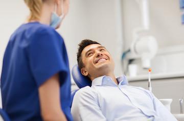 man smiling in dental chair after cleaning in manhattan beach