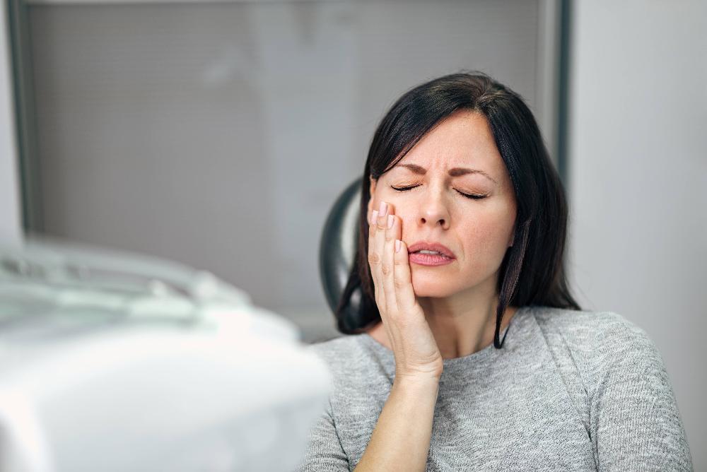 woman holding jaw from dental pain during emergency