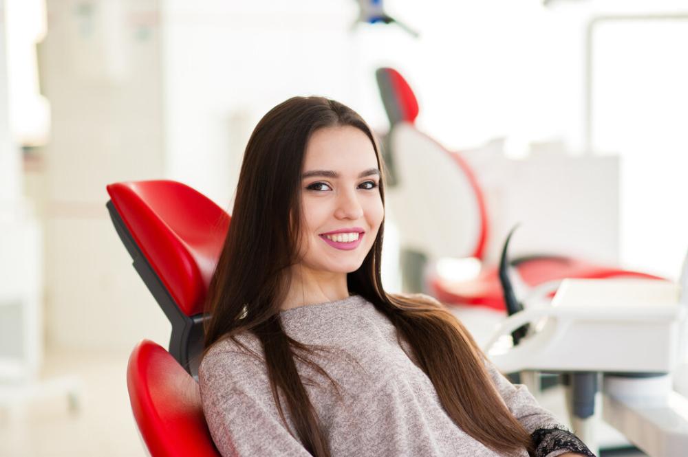 woman smiling in dental chair after cleaning