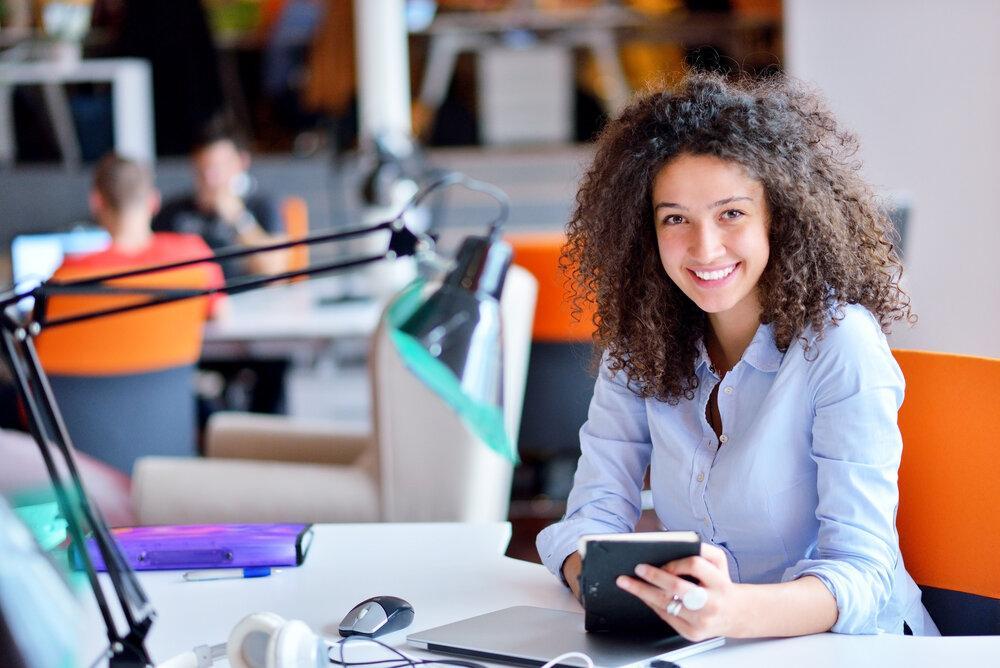 woman smiling while sitting at a desk in the office