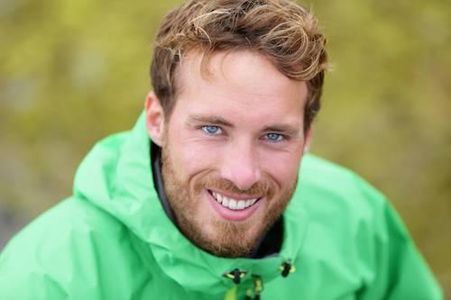 man smiling with green jacket and rested after having sleep apnea treated