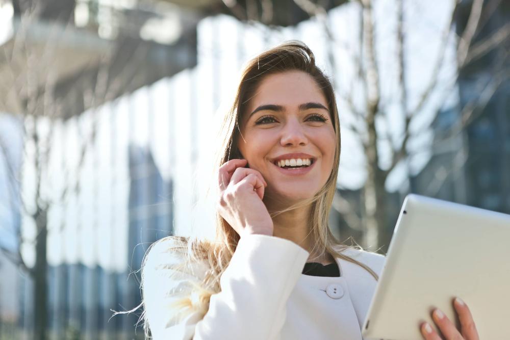 woman smiling while working on a tablet