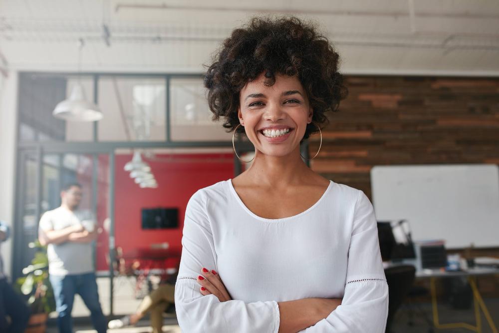 woman smiling in office after getting teeth whitening