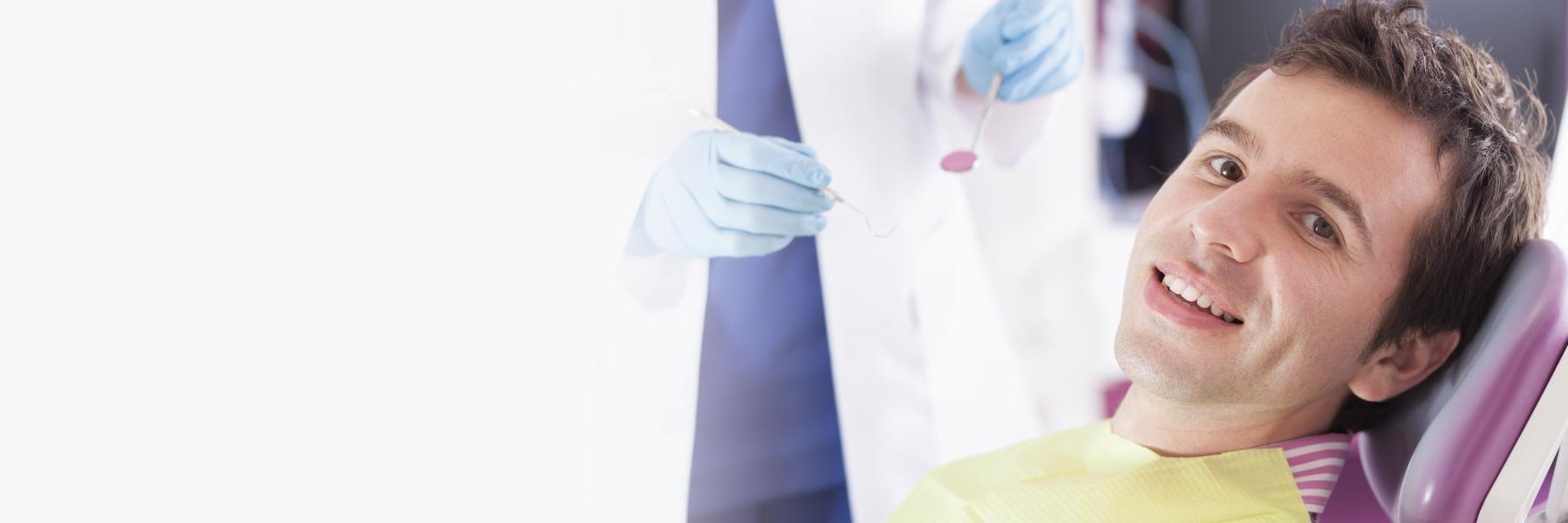 man smiling in purple dental chair