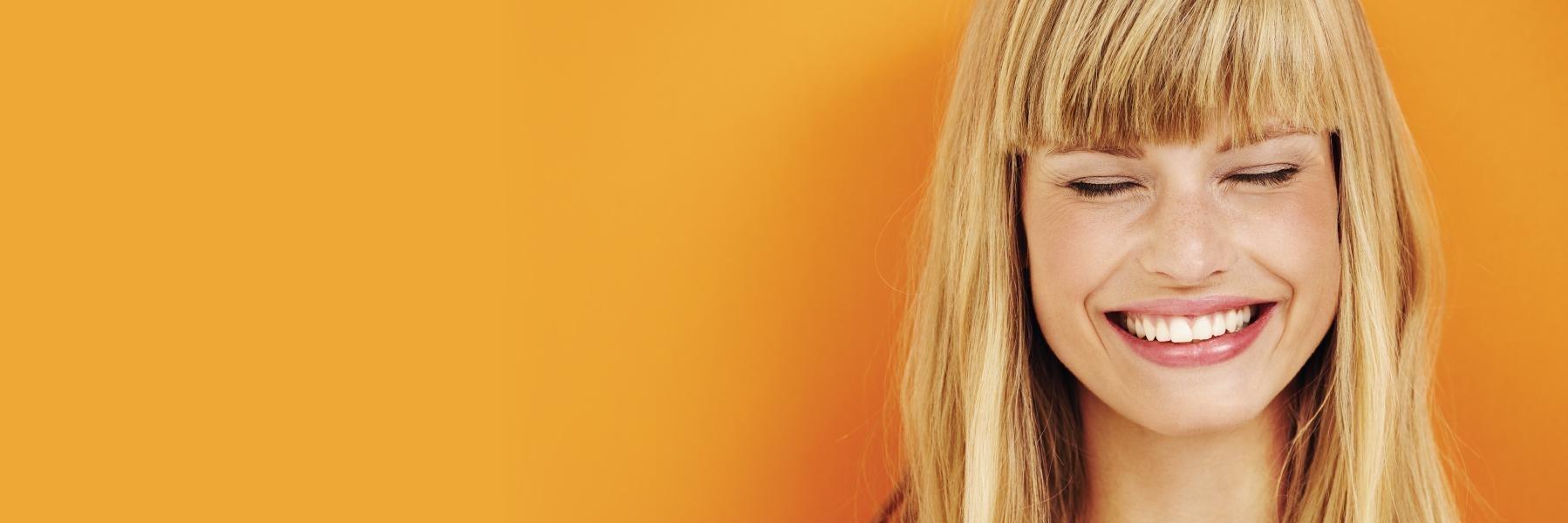 woman smiling after getting emergency dental care at modern american dentistry