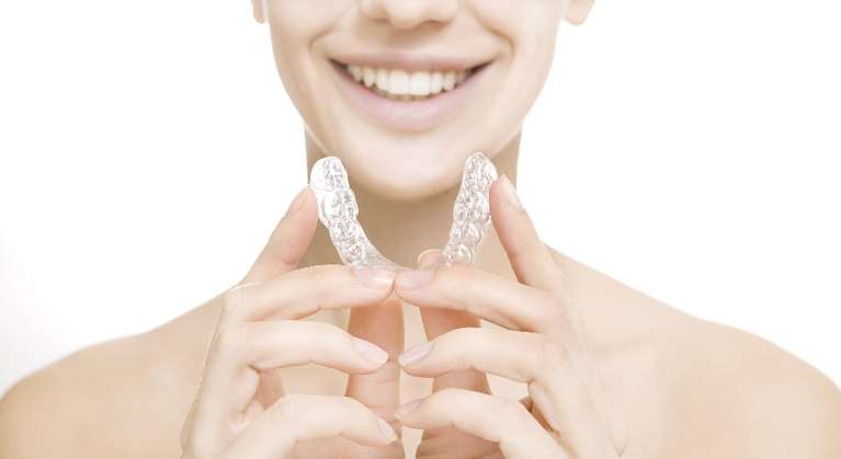 woman holding invisalign clear alignets 