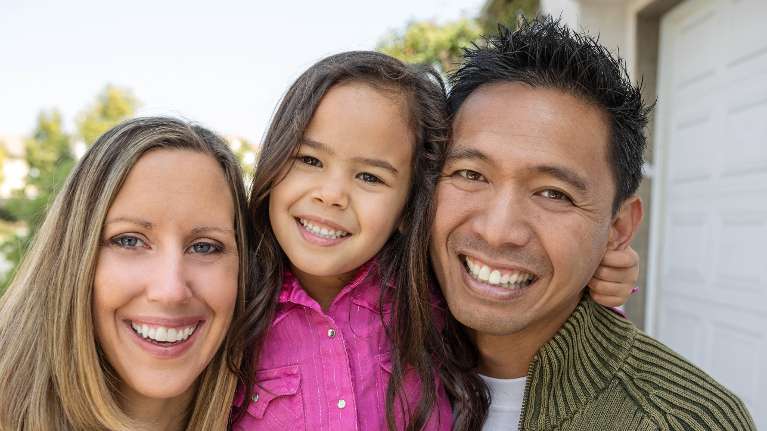 mom, dad, and daughter smiling in woodland hills
