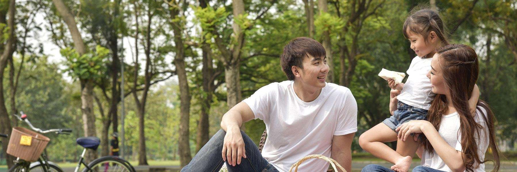 father, mother, and child having a picnic in a woodland hills park